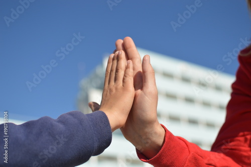 Close up on hand of mother and child on sunny outdoors background. Happy assistance, healthy motion togetherness. Human love, relation, protection support. Holding emotional connection.