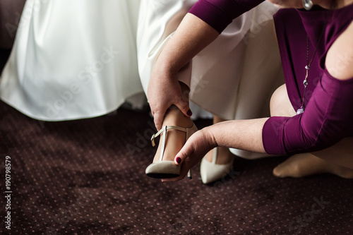 bride wears white shoes on foot in the wedding day