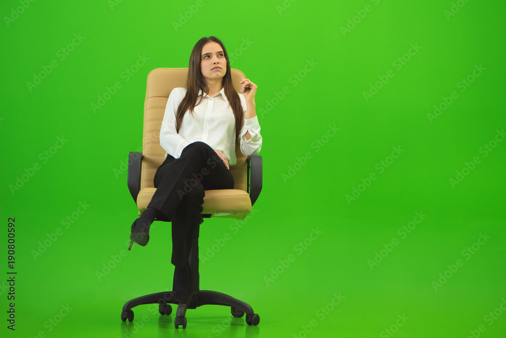 The woman sitting on the chair on the green background The woman sitting on the chair on the green background