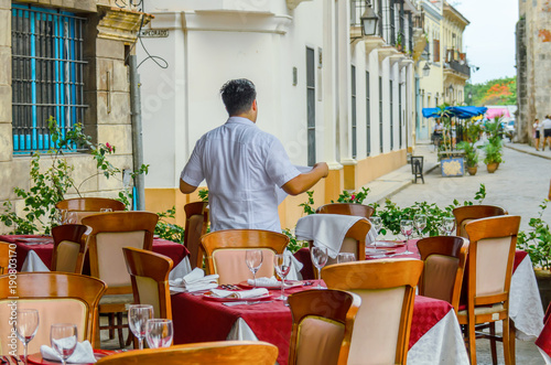 Obraz na płótnie serving tables of the restaurant by the waiter in anticipation of visitors on the streets of the city w salonie