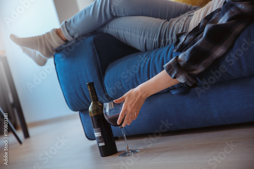 Young woman at home in the living room drinking wine close-up