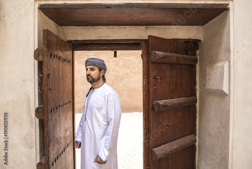 arab man in traditional omani outfit in an old castle © katiekk2