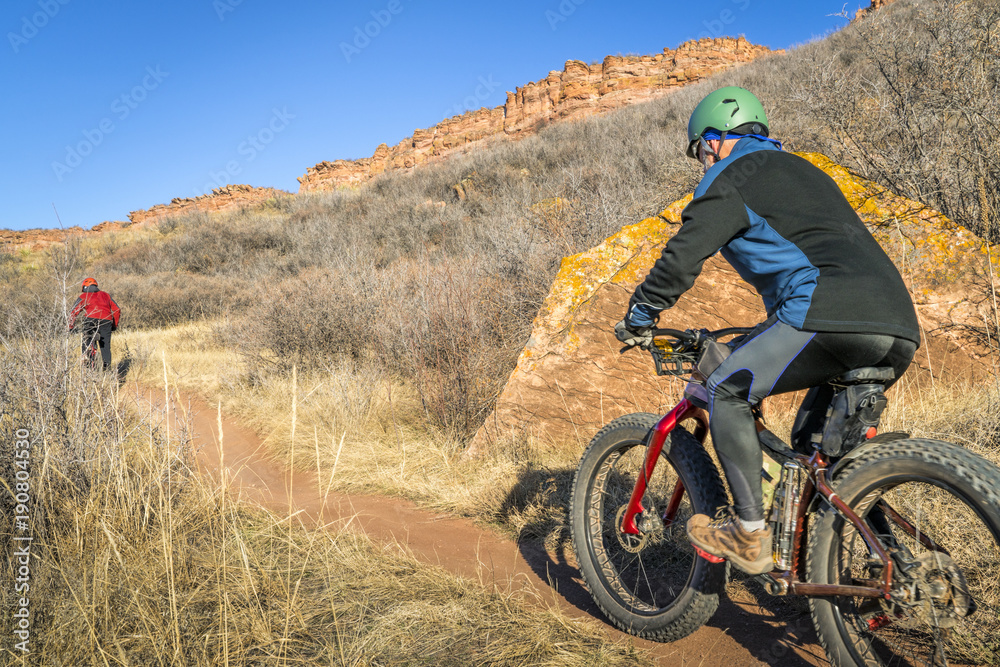 Obraz premium mountain bikers riding trail at Colorado foothills