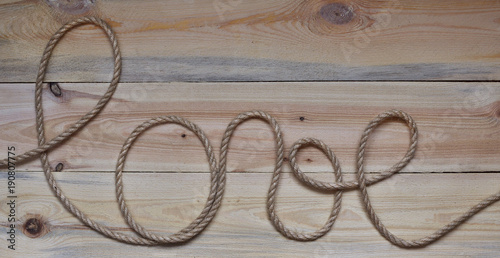 word "love" written in country-style by a rope laid out on a wooden background. holiday of all lovers. Valentine's Day, hand made valentines. valentines