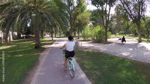 Attractive Young Brunette Girl Riding Rented Tourisctic Bicycle On Alley Of Turia River Park, Valencia, Spain, Europe, OCT 2017 photo