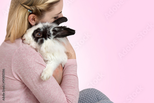 Woman holding cute fluffy rabbit.Lovely pets. 