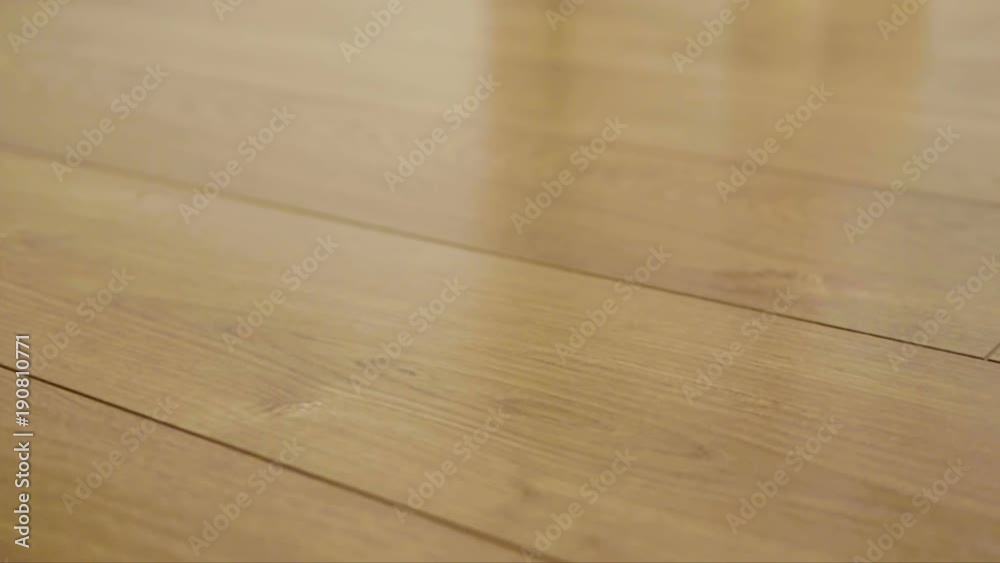 The camera moves along the floor, covered with laminated parquet with a brown wooden texture The camera moves along the floor, covered with laminated parquet with a brown wooden texture