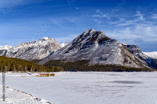 Winter landscape of the frozen Lake Minnewanka surrounded by the Canadian Rockies in Banff National Park, Alberta, Canada