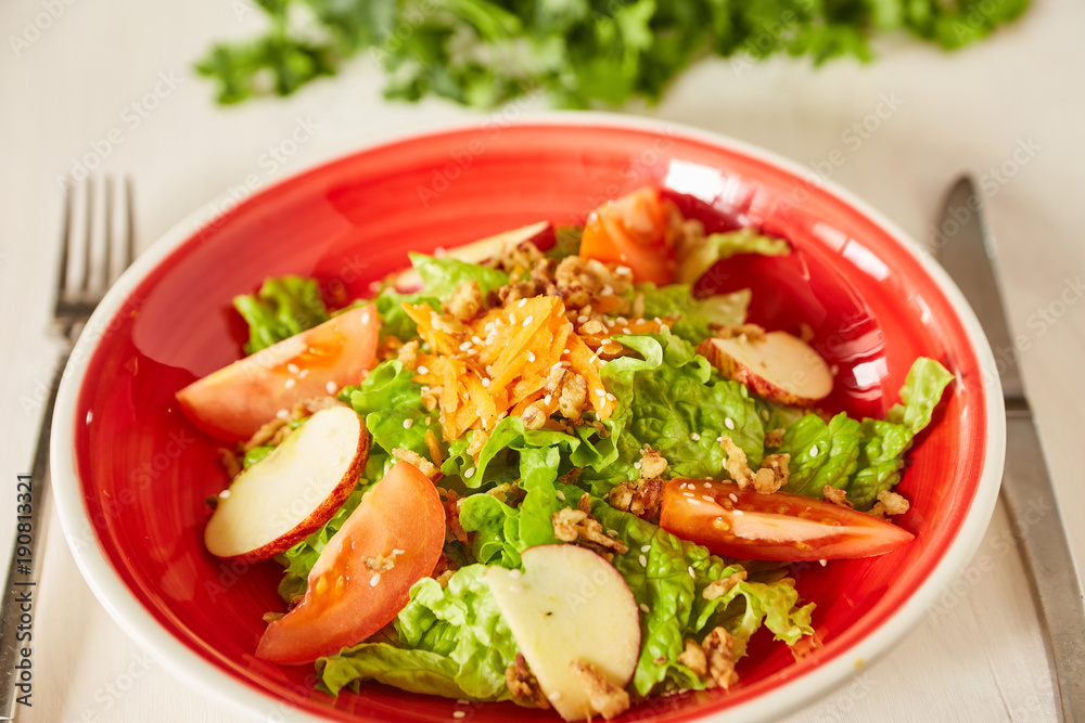 Bright vegetable salad with apple, tomatoes and carrot. Love for a healthy raw food concept. Perfect for the detox diet or just a healthy meal.