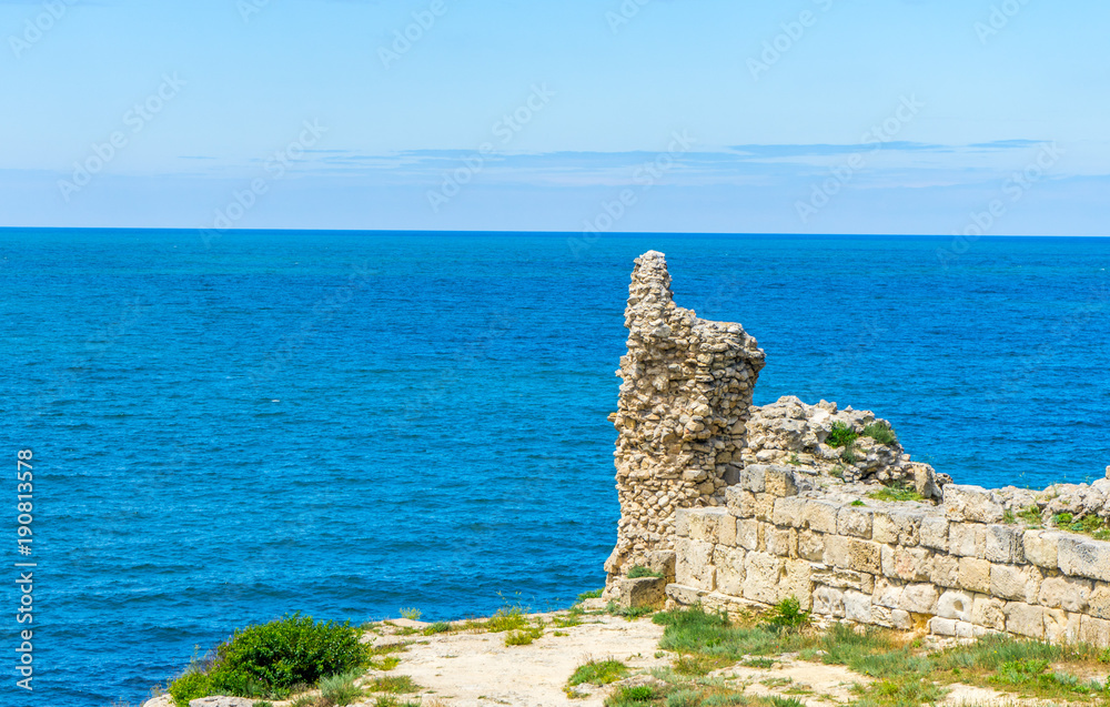 Ruins of an ancient wall and a view of the Black Sea in Chersonese, an ancient city on the territory of Sevastopol in the Crimea, in Russia