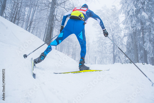 A man cross-country skiing in front of winter landscape
