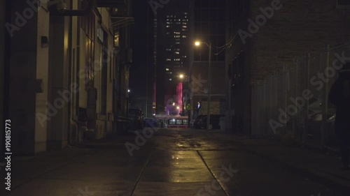 Dark winter alleyway with mysterious futuristic glowing building
