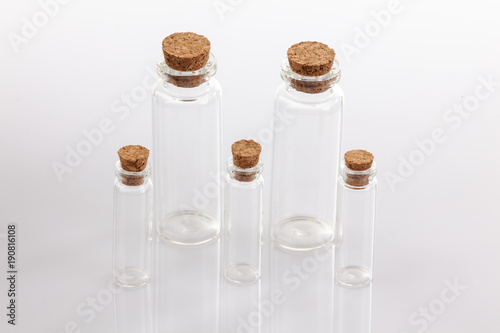 Glass container with cork stopper on white background.