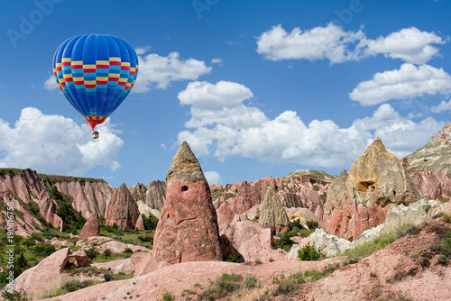 Colorful hot air balloon flying over Red valley at Cappadocia, Anatolia, Turkey. Volcanic mountains in Goreme national park.