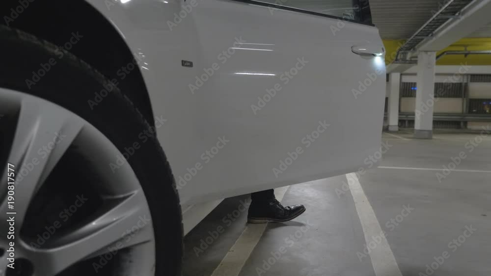 man getting out of a car parked in a garage