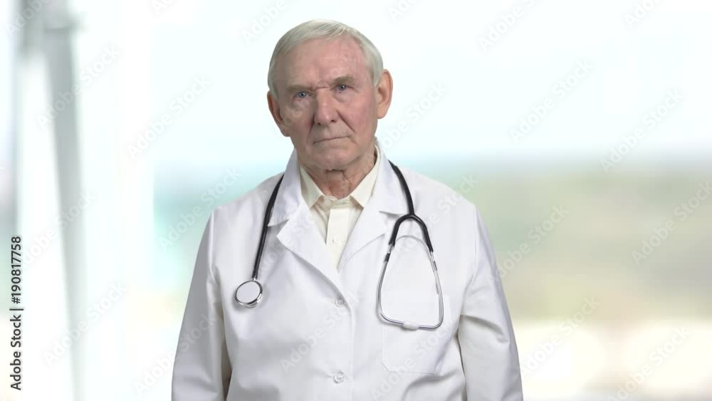 Old frown serious doctor. Touching gloomy face, bright abstract background. Old frown serious doctor. Touching gloomy face, bright abstract background.