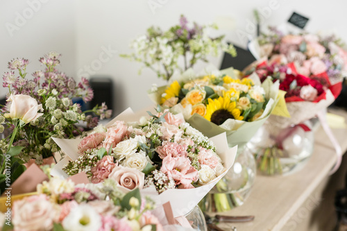 Fototapeta Naklejka Na Ścianę i Meble -  Bouquets on table, florist business. Different varieties fresh spring flowers. Delivery service. Flower shop concept.