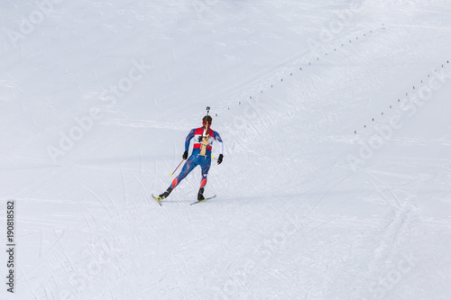 Cuadro en lienzo Biathlon racing, biathlete skiing with rifle on his back
