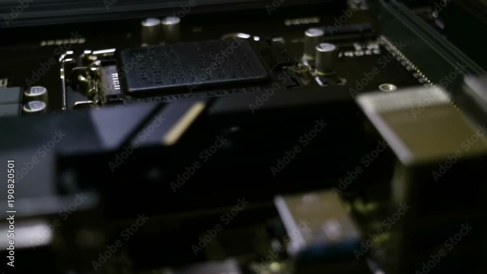 Big printed circuit board. Many electronic components such as capacitors, resistors, switches, radiators. Motherboard closeup. Glide view