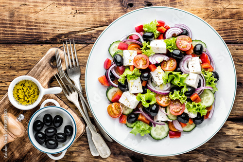 Greek salad of fresh cucumber, tomato, sweet pepper, lettuce, red onion, feta cheese and olives with olive oil. Healthy vegetarian food