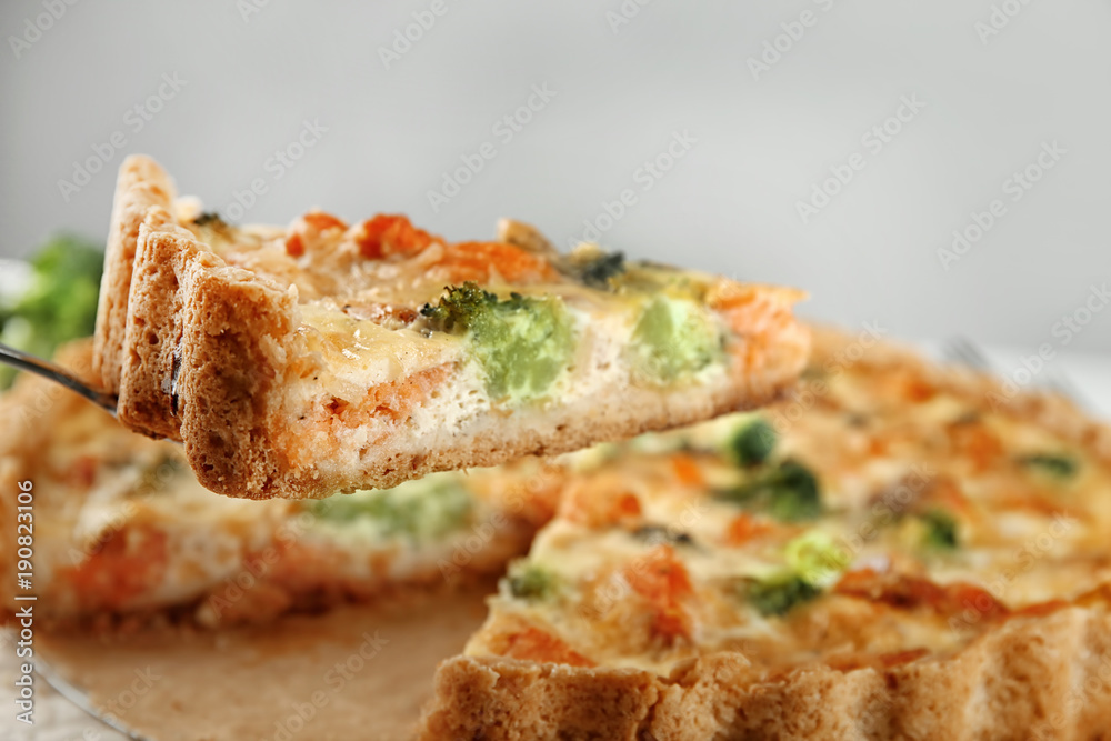 Piece of tasty broccoli quiche on spatula, closeup