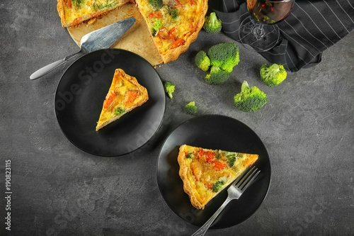 Plates with tasty broccoli quiche on table