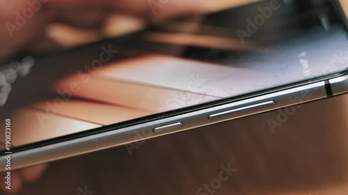 Man pressing power button on smartphone. Turning phone on and off.