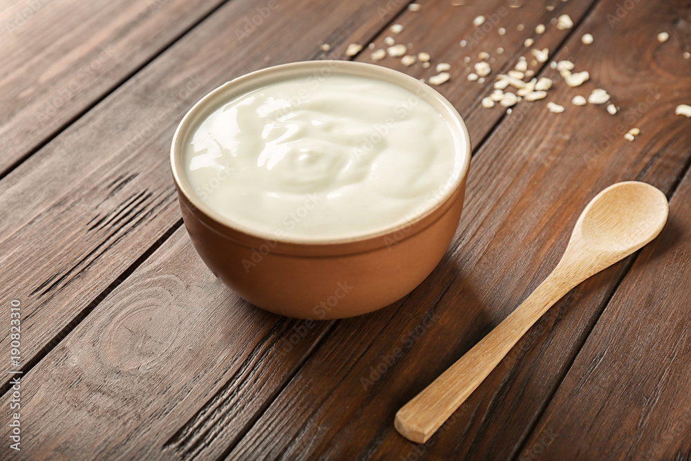 Tasty yogurt in dish on wooden table Tasty yogurt in dish on wooden table
