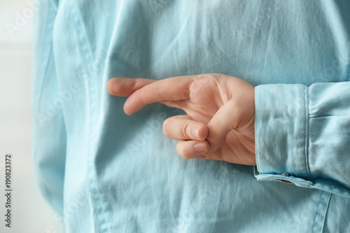 Foto Man holding crossed fingers behind his back, closeup
