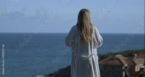 attractive woman getting into the swimming pool at villa with ocean view