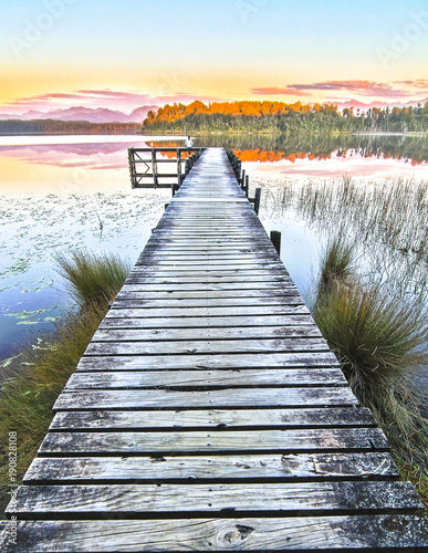 A long dock stretching out over Lake Mahinapua is seen at sunset on New Zealand's south island.