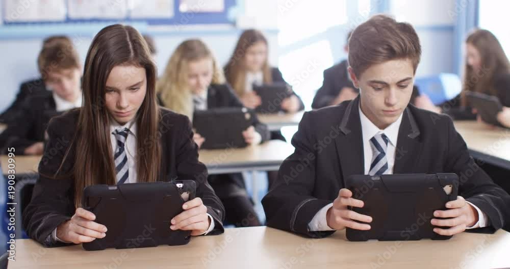 4k, Students using a digital tablet while studying in a classroom. Slow motion. 4k, Students using a digital tablet while studying in a classroom. Slow motion.