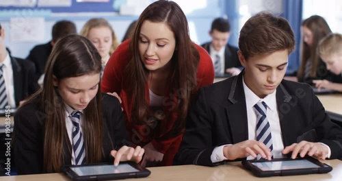 4k, young teacher spending some one-on-one time with her students during class.