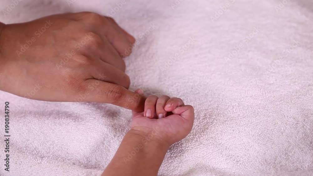 Newborn baby boy gripping mother's finger Newborn baby boy gripping mother's finger