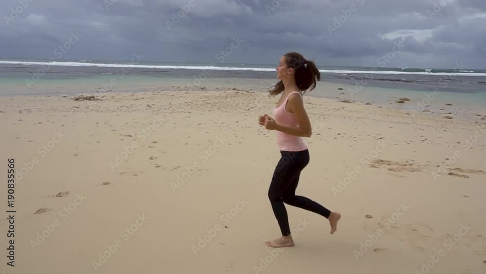 Young woman with a slender figure is engaged in jogging at sea at sunrise. Young woman with a slender figure is engaged in jogging at sea at sunrise.
