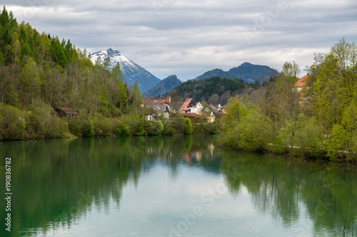 Fussen, romantic Bavarian city in Germany, reflective view on river.