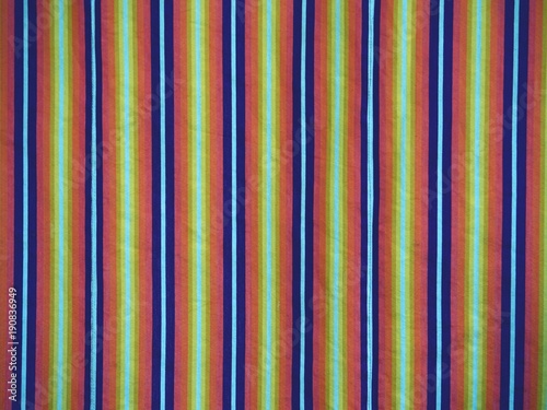Colorful striped curtains cover window in hall. Wavy colorful fabric curtains
