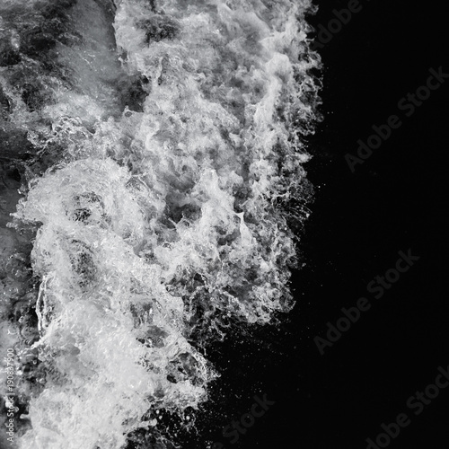 Beautiful sea wave with water spray and foam, photographed from aboard of a sailing yacht. Top view. Bw.
