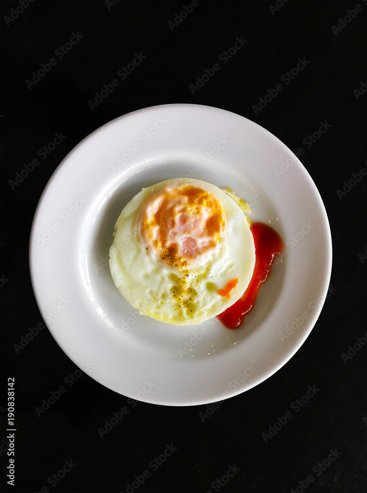 Fried eggs in a white plate ,Top view, black background. Fried eggs in a white plate ,Top view, black background.