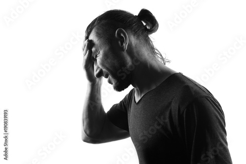 Fototapeta Frustrated man with headache-silhouette isolated over white