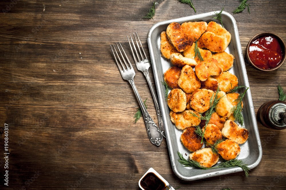 Chicken nuggets on a steel tray with sauce. Chicken nuggets on a steel tray with sauce.