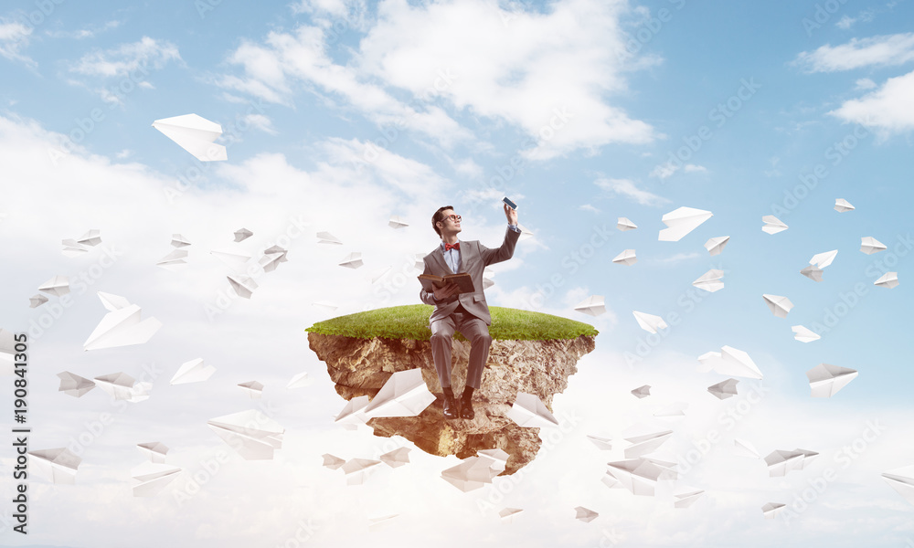 Young businessman or student studying the science and paper planes fly around