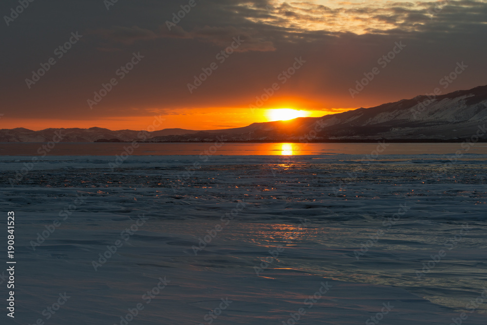 The reflection of sunset on winter lake Baikal