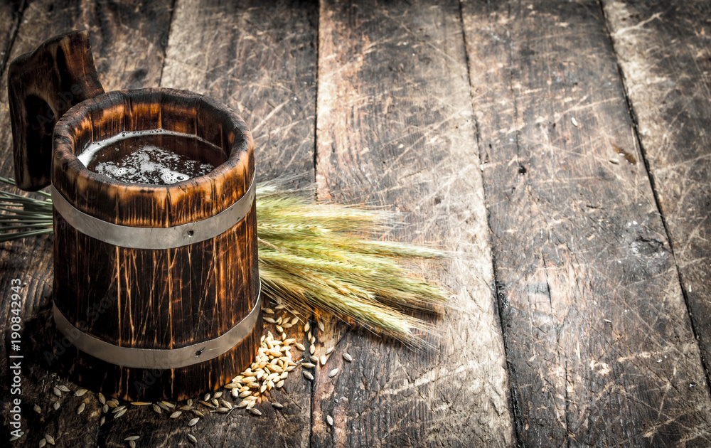 Fototapeta premium Fresh beer in a wooden mug.
