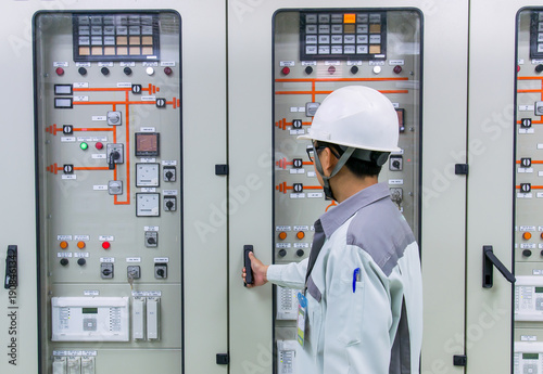 Engineer and 115kV control and protection panel at power plant