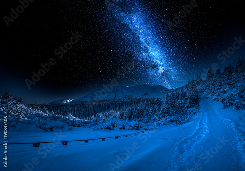 Mountain path in mountains in winter with stars