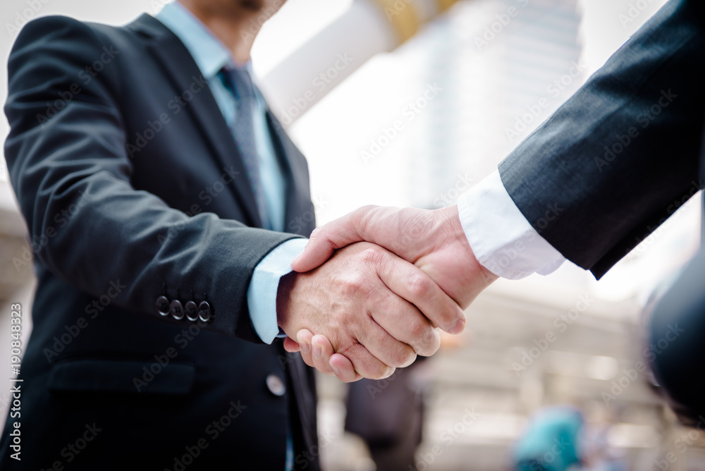 Business people shaking hands, Greeting Deal Concept, modern city background.