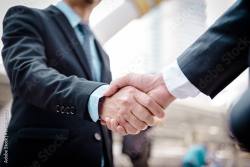 Obraz na płótnie Business people shaking hands, Greeting Deal Concept, modern city background. w salonie
