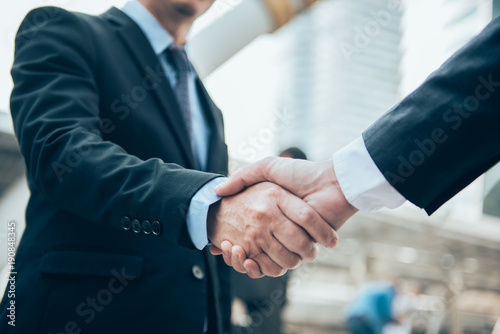 Business people shaking hands, Greeting Deal Concept, modern city background.