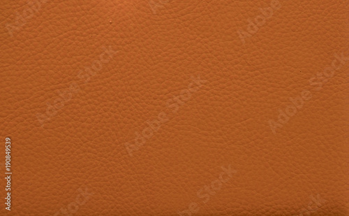 Orange leather background. Red leather texture. Toned leather book cover closeup.